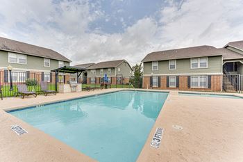 A swimming pool in front of apartment buildings.